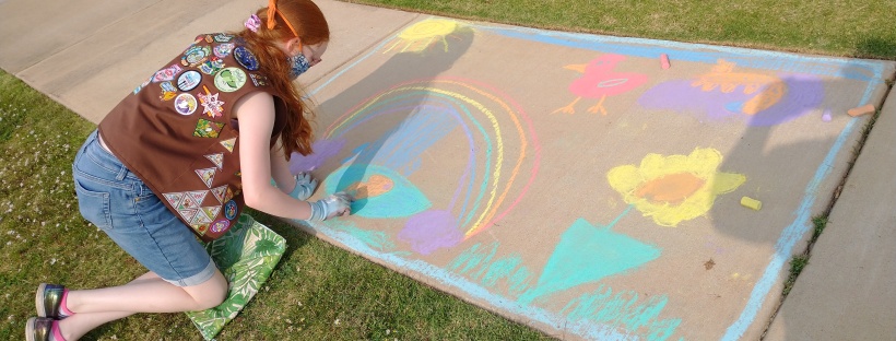 young Girl Scout creating sidewalk chalk art